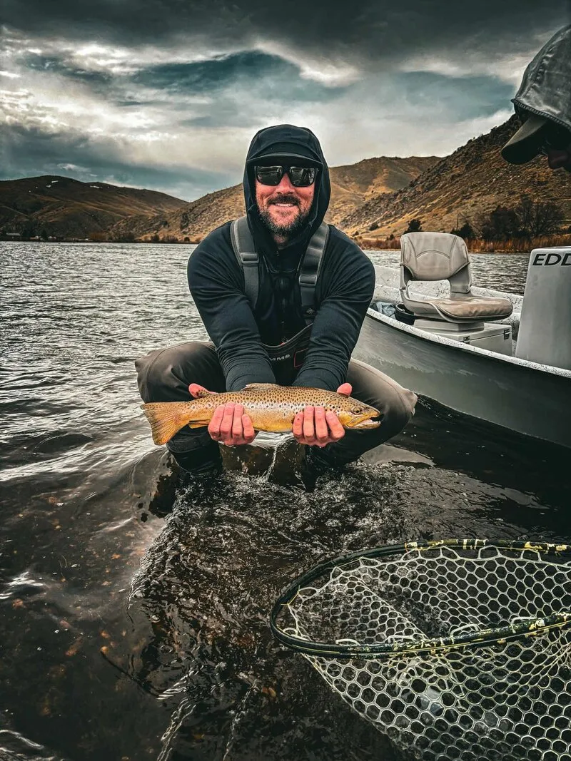 Andrew Osborn with a brown trout in the river