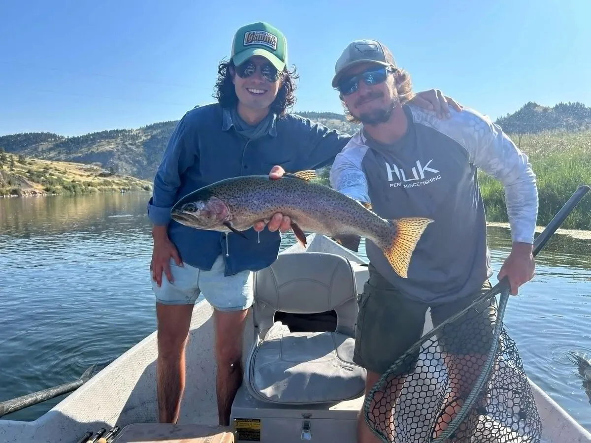 Two anglers with a rainbow trout on a group trip