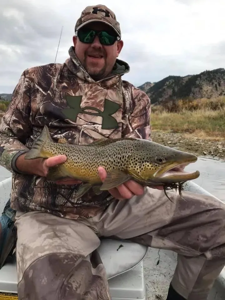 Angler with a brown trout in early season on the Missouri
